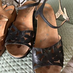 2 pair Dansko heeled sandals. One brown leather and one black.
